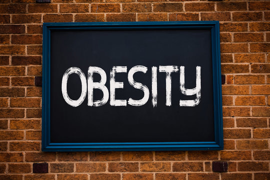 Conceptual hand writing showing Obesity. Business photo showcasing Medical condition Excess of body fat accumulated Health problem Framed hang black board study class brick wall background