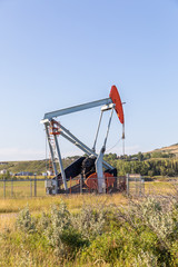 Fototapeta na wymiar Small oil/gas pumpjack in the field. Alberta, Canada.