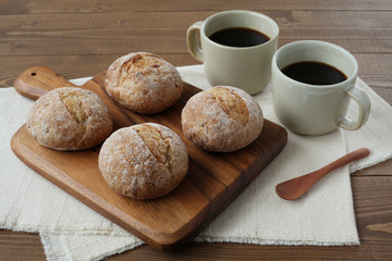 まな板にのせたフランスのパン ライ麦パン ホットコーヒー 木のテーブル