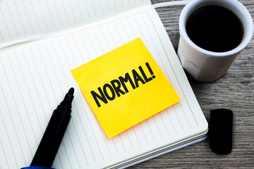 Handwriting text Normal Motivational Call. Concept meaning conforming to a standard Usual Typical or Expected Study material folder card register notebook pen cap tea coffee cup table