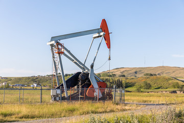 Fototapeta premium Close up of an oil pumpjack at a farm field. Alberta, Canada. Oil Pump. 