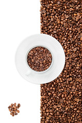 Cup of coffee beans facing 7 o'clock, bunch of coffee beans in the left bottom corner