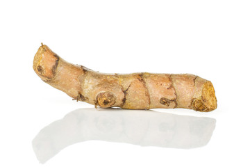One whole ripe bright turmeric rhizome isolated on white background