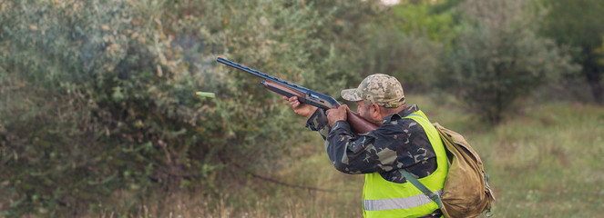 Hunter with a german drathaar and spaniel, pigeon hunting with dogs in reflective vests	