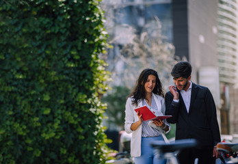 Serious colleagues chatting and standing on street
