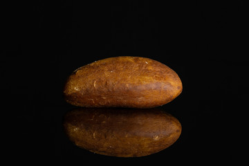 Fototapeta na wymiar One whole unshelled brazil nut isolated on black glass