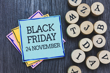 Handwriting text Black Friday 24 November. Concept meaning Special sales Thanksgiving discounts Clearance Black wooden deck written sticky note beside some round woody alphabets