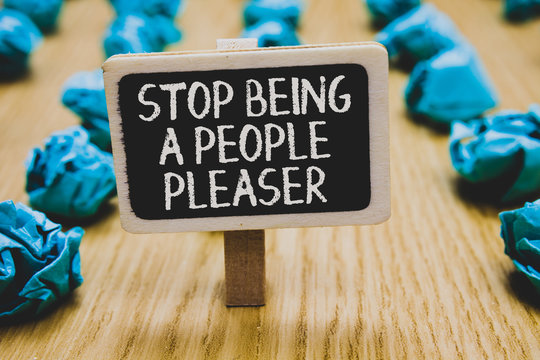 Handwriting text writing Stop Being A People Pleaser. Concept meaning Do what you like not things other people want Stand blackboard with white words behind blurry blue paper lobs woody floor