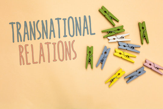 Text sign showing Transnational Relations. Conceptual photo International Global Politics Relationship Diplomacy Yellow base with painted texts colorful paper clips laid randomly on ground