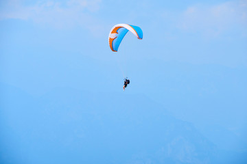 Paraglider flying over the Garda Lake (Lago di Garda or Lago Benaco). Paragliding on Monte Baldo. Panorama of the gorgeous Garda lake surrounded by mountains, Malcesine, Italy