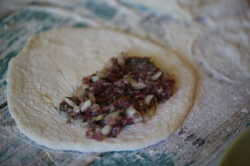 on the table, flour the rolling pin and the hostess prepares pasties