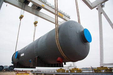 Harbor gantry crane moving a tank container