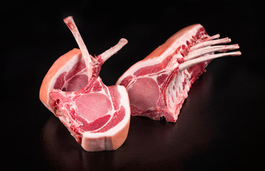 Rohe dry aged Tomahawk Steak vom Schwein aufgeschnitten als closeup angeboten vor schwarzen...