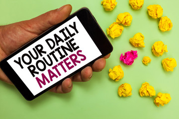 Word writing text Your Daily Routine Matters.. Business concept for Have good habits to live a healthy life Man holding cell phone white screen looking messages crumpled papers
