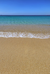 Fototapeta na wymiar Wave rippling on perfect beach and clear turquoise sea in Agios Prokopios, Naxos, Greek Islands