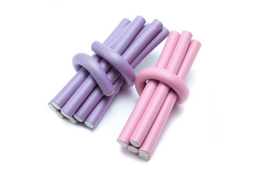 Lilac and pink  hair curlers on a white background