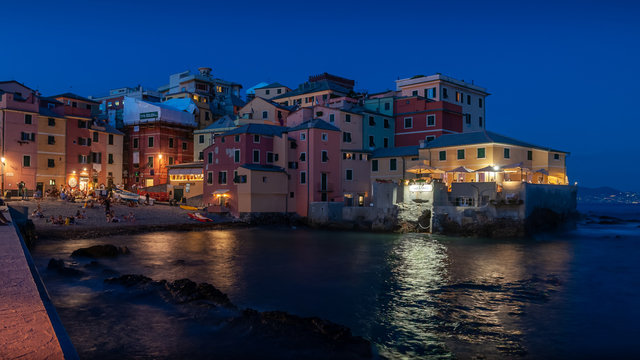Genoa, Italy. Incredible night view of the ancient fishing village of Boccadasse overlooking the sea. Reflections of lights on the waters of the sea