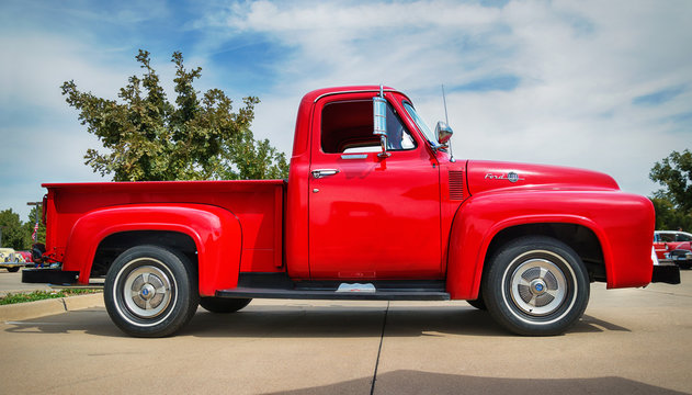 Side view of a red 1955 Ford F-100 Pickup Truck classic car on October 17, 2015 in Westlake, Texas.