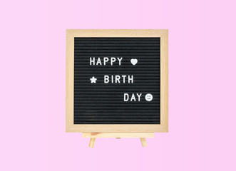 Closeup a board with happy birth day word isolated on pink background