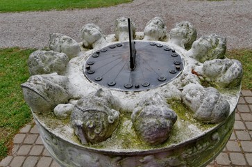 Köpfe rund um Sonnenuhr