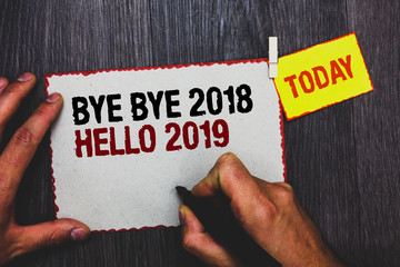 Handwriting text writing Bye Bye 2018 Hello 2019. Concept meaning Starting new year Motivational message 2018 is over Hand grip black marker writing text paperclip stick written page woody deck © A