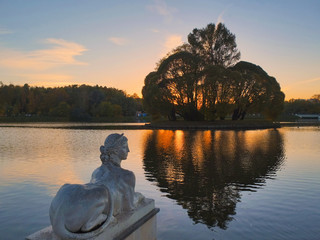 Sculpture on the shore of the pond at sunset in the fall. Tsaritsyno, Moscow