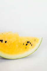 cut a slice of ripe yellow melon on a white background