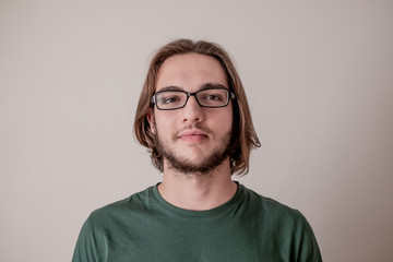 Young college student guy looking at camera, portrait of smiling young boy with eyeglasses