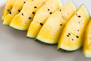 cut a slices of ripe yellow melon on a white background