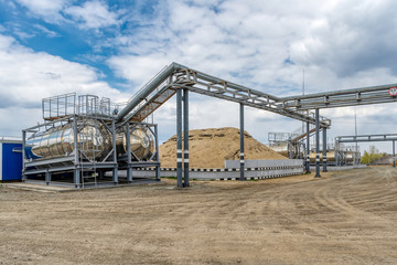 Fototapeta premium Street tanks for storing various liquids. Tanks are connected by many different pipelines.