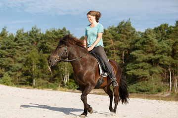 Reiterin mit Isländer in der Heide