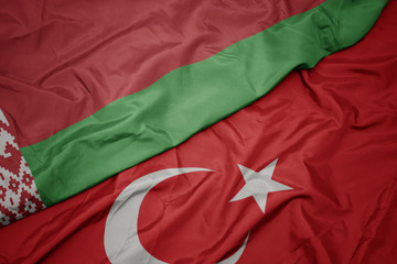 waving colorful flag of turkey and national flag of belarus.