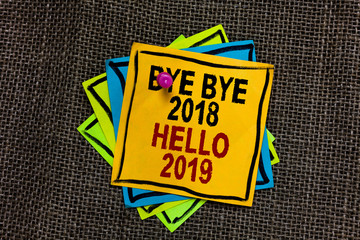 Text sign showing Bye Bye 2018 Hello 2019. Conceptual photo Starting new year Motivational message 2018 is over Black bordered different color sticky note stick together with pin on jute sack © A