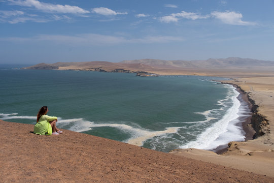 Woman watching the red beach in the  Paracas reserve Peru