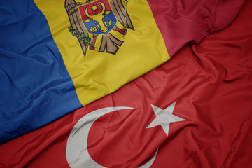 waving colorful flag of turkey and national flag of moldova.