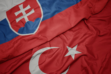 Fototapeta premium waving colorful flag of turkey and national flag of slovakia.