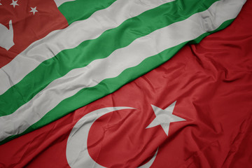waving colorful flag of turkey and national flag of abkhazia.
