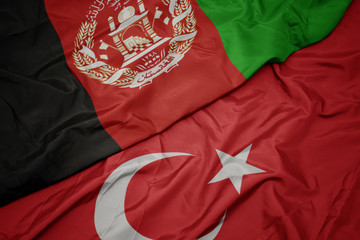 waving colorful flag of turkey and national flag of afghanistan.