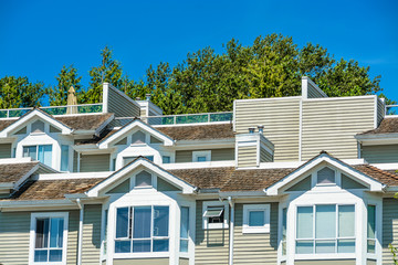 Top of residential townhouses on blue sky background.