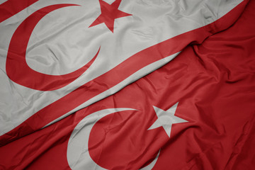 waving colorful flag of turkey and national flag of northern cyprus.