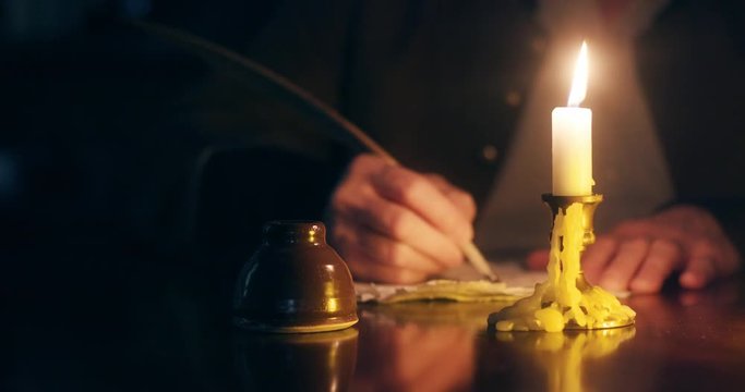 man in the mid 1700s writing with a quill pen blows out candle