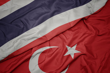 waving colorful flag of turkey and national flag of thailand.