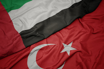 waving colorful flag of turkey and national flag of united arab emirates.