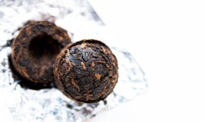 Chinese PU-erh tea in the shape of a ball of old fragrant tea and dry cylindrical bricks. Fragrant black PU-erh tea. Healthy drink
