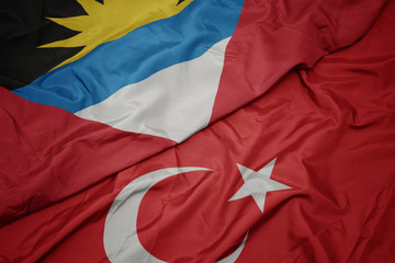 waving colorful flag of turkey and national flag of antigua and barbuda.