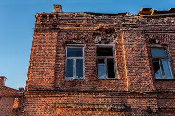 Fototapeta premium The facade of an ancient brick abandoned building