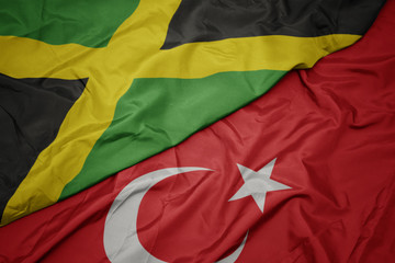 waving colorful flag of turkey and national flag of jamaica.