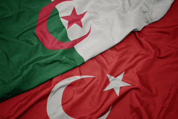 waving colorful flag of turkey and national flag of algeria.