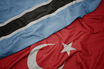 waving colorful flag of turkey and national flag of botswana.