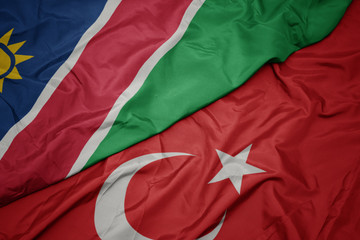 waving colorful flag of turkey and national flag of namibia.